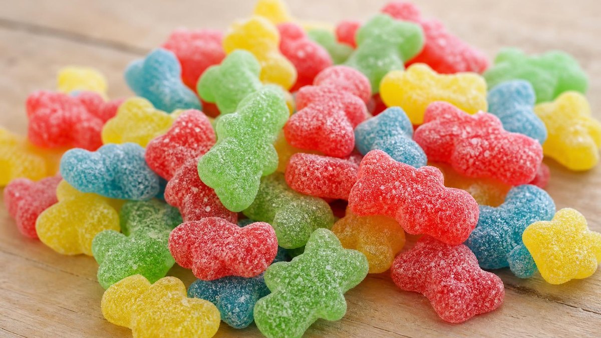 Sugar-coated sour gummy figures in red, yellow, green and blue
